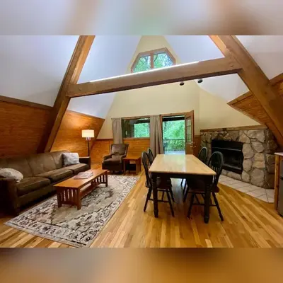 a living room with a table and a fireplace at A-Frame #07 - by The Chalets in Logan