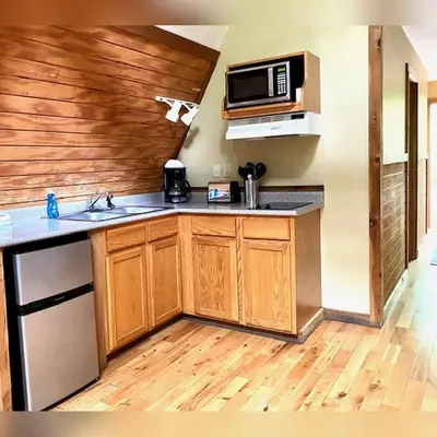 a kitchen with a sink and a microwave at A-Frame #11 - by The Chalets in Logan