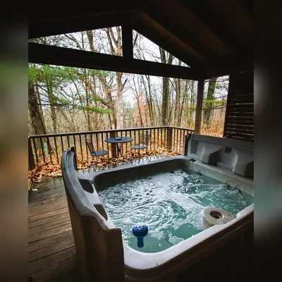 a hot tub on a deck with a table at A-Frame #12 - by The Chalets in Logan