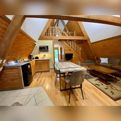 a kitchen and living room with a table and chairs at A-Frame #12 - by The Chalets in Logan