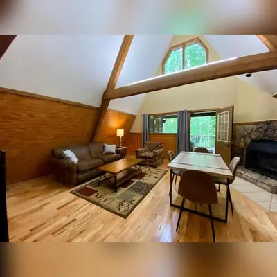 a living room with a couch and a table at A-Frame #12 - by The Chalets in Logan
