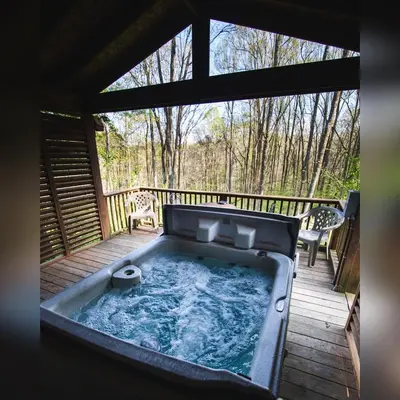 a hot tub on a deck with two chairs at A-Frame #14 - by The Chalets in Logan