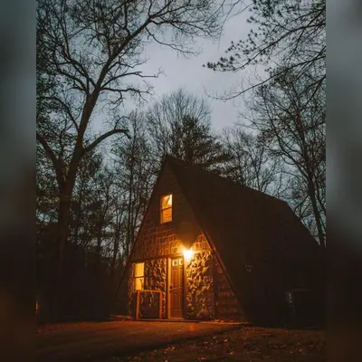 a barn with a light on the front at night at A-Frame #15 - by The Chalets in Logan