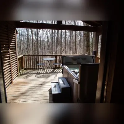 a screened in porch with a table on a deck at A-Frame #15 - by The Chalets in Logan
