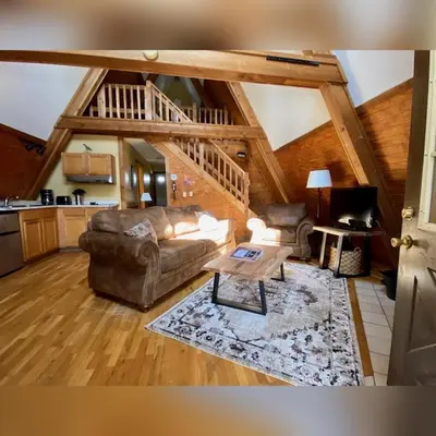 a living room with a couch and a table at A-Frame #17 - by The Chalets in Logan