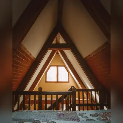 a room with a large window in a attic at A-Frame #17 - by The Chalets in Logan