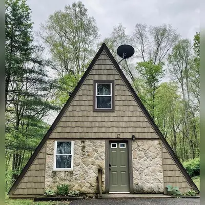 a small house with a pointed roof with a garage at A-Frame #17 - by The Chalets in Logan
