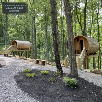 a wooden cabin in the woods with a tree at A-Frame #17 - by The Chalets in Logan