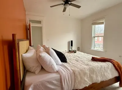 a bedroom with a bed with white sheets and pillows at Jungle House Columbus Sleep 12 Downtown Ohio Free Parking - Near Convention Center & Nationwide Arena - 4BR Short North Luxury Home - Over 5,800 Five Star Stays in Columbus