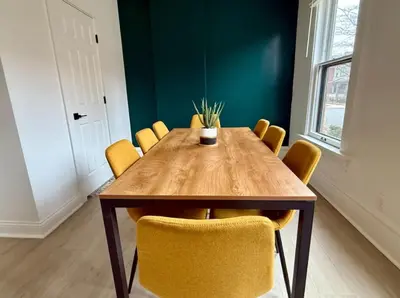 a dining room with a wooden table and yellow chairs at Jungle House Columbus Sleep 12 Downtown Ohio Free Parking - Near Convention Center & Nationwide Arena - 4BR Short North Luxury Home - Over 5,800 Five Star Stays in Columbus