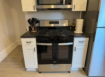 a kitchen with a stove and a microwave at Jungle House Columbus Sleep 12 Downtown Ohio Free Parking - Near Convention Center & Nationwide Arena - 4BR Short North Luxury Home - Over 5,800 Five Star Stays in Columbus