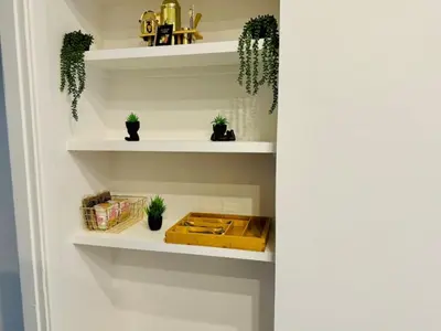 a room with white shelves with potted plants at Jungle House Columbus Sleep 12 Downtown Ohio Free Parking - Near Convention Center & Nationwide Arena - 4BR Short North Luxury Home - Over 5,800 Five Star Stays in Columbus