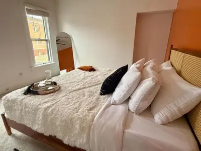 a bedroom with a bed with white sheets and pillows at Jungle House Columbus Short North Downtown Free Parking - Near Convention Center & Nationwide Arena - 4BR Luxury Home - Sleeps 12 - Over 5,800 Five Star Stays in Columbus