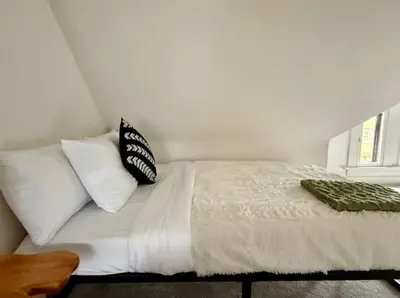 a bed with white sheets and pillows in a bedroom at Jungle House Columbus Short North Downtown Free Parking - Near Convention Center & Nationwide Arena - 4BR Luxury Home - Sleeps 12 - Over 5,800 Five Star Stays in Columbus