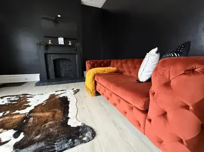 a living room with a red couch and a fireplace at Jungle House Columbus Short North Downtown Free Parking - Near Convention Center & Nationwide Arena - 4BR Luxury Home - Sleeps 12 - Over 5,800 Five Star Stays in Columbus