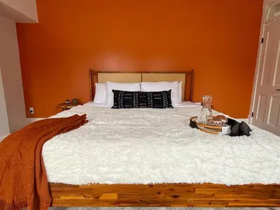 a bedroom with a large bed with an orange wall at Jungle House Luxury Stays - Columbus Downtown Short North in Columbus