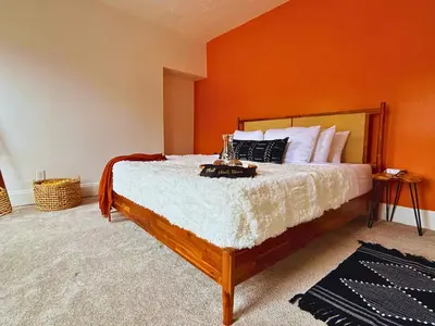 a bedroom with a large bed with an orange wall at Jungle House Luxury Stays - Columbus Downtown Short North in Columbus
