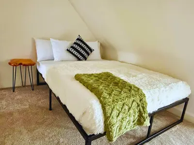 a bed with a green blanket on top of it at Jungle House Luxury Stays - Columbus Downtown Short North in Columbus