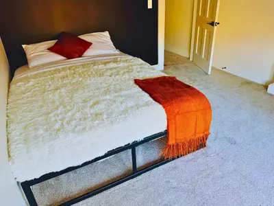 a bed with an orange blanket on top of it at Jungle House Luxury Stays - Columbus Downtown Short North in Columbus