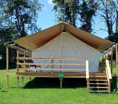 a large tent in the grass in a field at Fantastic Secluded Tented Cabin with Fire Pit in Logan, Ohio in Logan