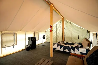 a bedroom in a tent with a bed in it at Hocking Hills Deluxe Safari Glamping Tents in Logan