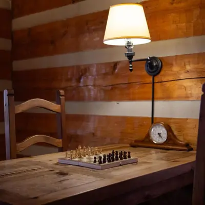 a table with a chess board and a lamp on it at Alpine - by The Chalets in Logan