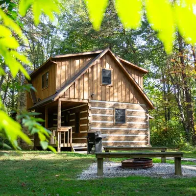 a log cabin with a bench in front of it at Alpine - by The Chalets in Logan