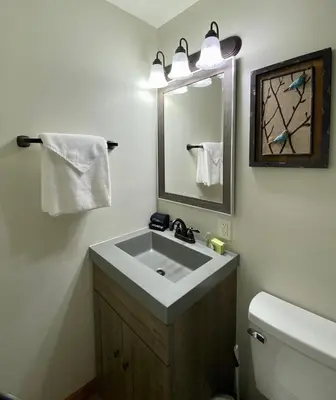 a bathroom with a sink and a mirror and a toilet at Aspen - by The Chalets in Logan
