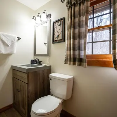 a bathroom with a toilet and a sink and a window at Aspen - by The Chalets in Logan