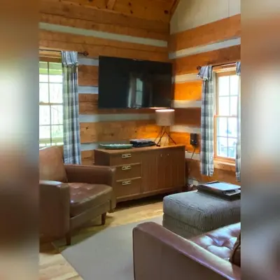 a living room with a couch and a flat screen tv at Aspen - by The Chalets in Logan