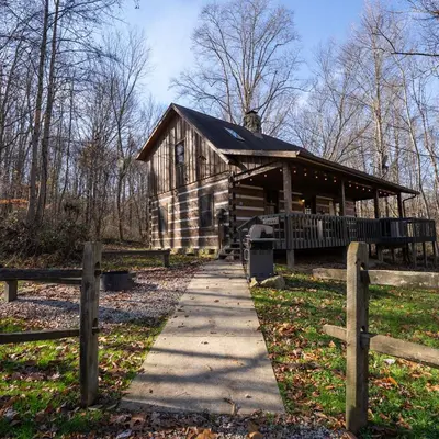 a log cabin with a sidewalk in front of it at Aspen - by The Chalets in Logan