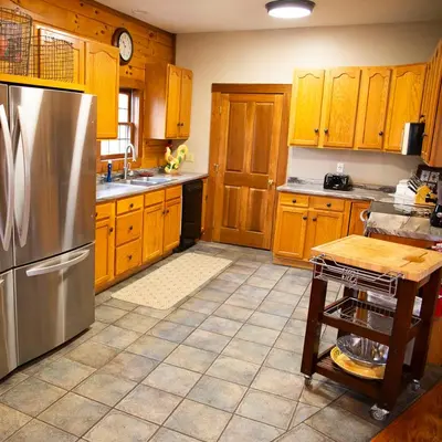 a kitchen with wooden cabinets and a stainless steel refrigerator at Big Sky Lodge - by The Chalets in Logan