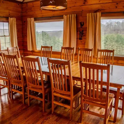 a dining room with a table and wooden chairs at Big Sky Lodge - by The Chalets in Logan
