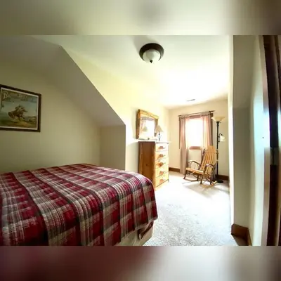 a bedroom with a bed and a chair in a room at Big Sky Lodge - by The Chalets in Logan
