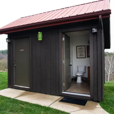 a black shed with a toilet in a yard at Big Sky Lodge - by The Chalets in Logan
