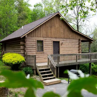 a log cabin with a staircase in front of it at Blackjack - by The Chalets in Logan