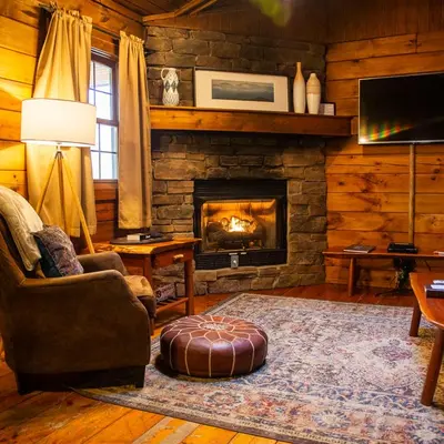 a living room with a fireplace in a log cabin at Blackjack - by The Chalets in Logan