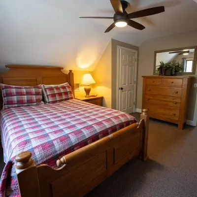 a bedroom with a bed and a ceiling fan at Couples Paradise I - by The Chalets in Logan