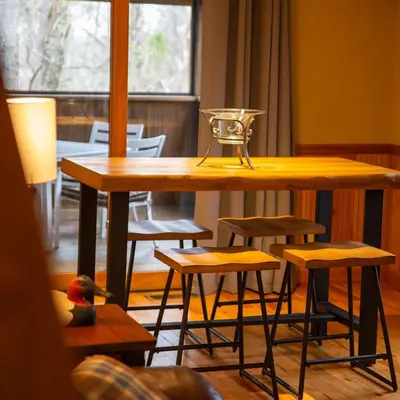 a wooden table and stools in a room at Couples Paradise II - by The Chalets in Logan