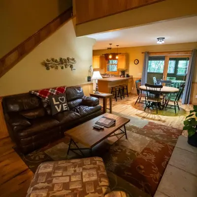 a living room with a leather couch and a table at Couples Paradise II - by The Chalets in Logan