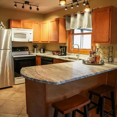 a kitchen with wooden cabinets and a granite counter top at Couples Paradise II - by The Chalets in Logan