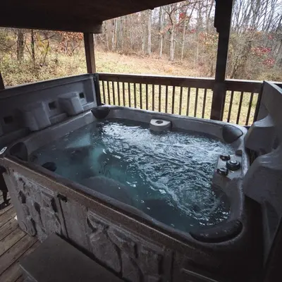 a hot tub sitting on a deck with water at Coyote - by The Chalets in Logan