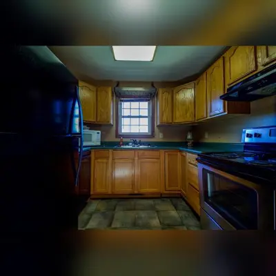 a kitchen with wooden cabinets and a window at Coyote - by The Chalets in Logan