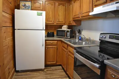 a white refrigerator in a kitchen with wooden cabinets at Cumberland - by The Chalets in Logan