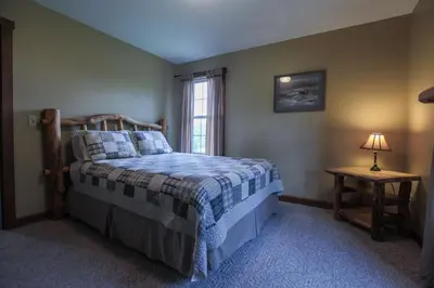 a bedroom with a bed and a window at Deer Run - by The Chalets in Logan