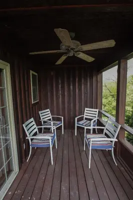 a porch with four chairs and a ceiling fan at Deer Run - by The Chalets in Logan
