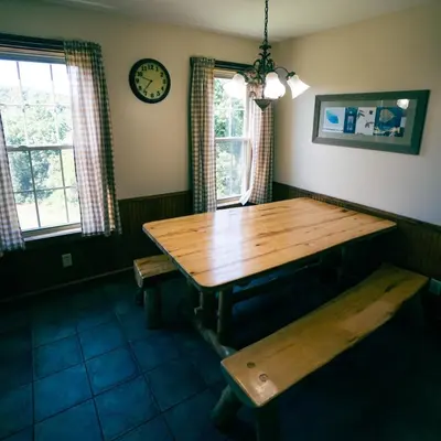 a dining room with a wooden table and a clock at Deer Run - by The Chalets in Logan