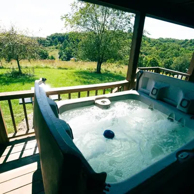 a hot tub on a deck with a view of a yard at Deer Run - by The Chalets in Logan