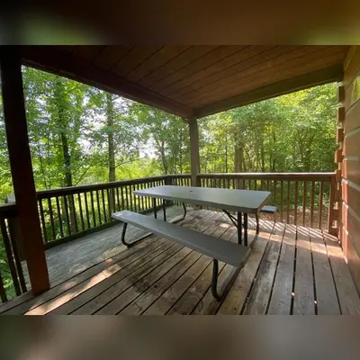 a wooden porch with a picnic table on a deck at Dogwood - by The Chalets in Logan