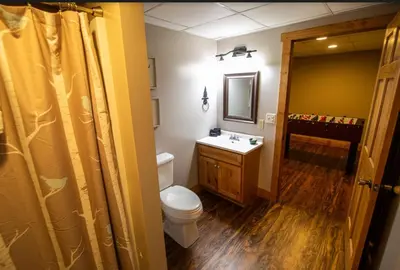 a bathroom with a toilet and a sink and a mirror at Dogwood - by The Chalets in Logan